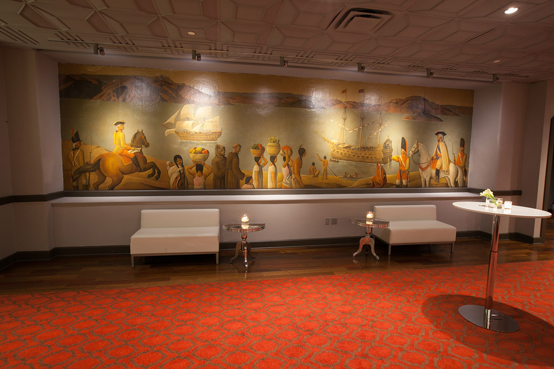 Lounge set against historic Jose Moya del Pino San Francisco murals